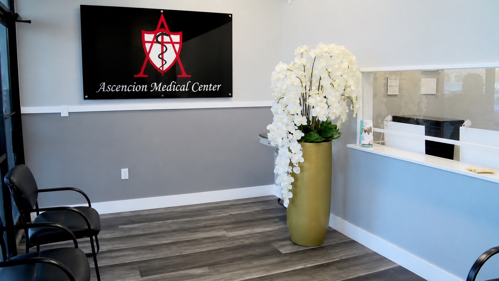 Recepción de Ascencion Medical Center con el letrero, las orquídeas y el mostrador.